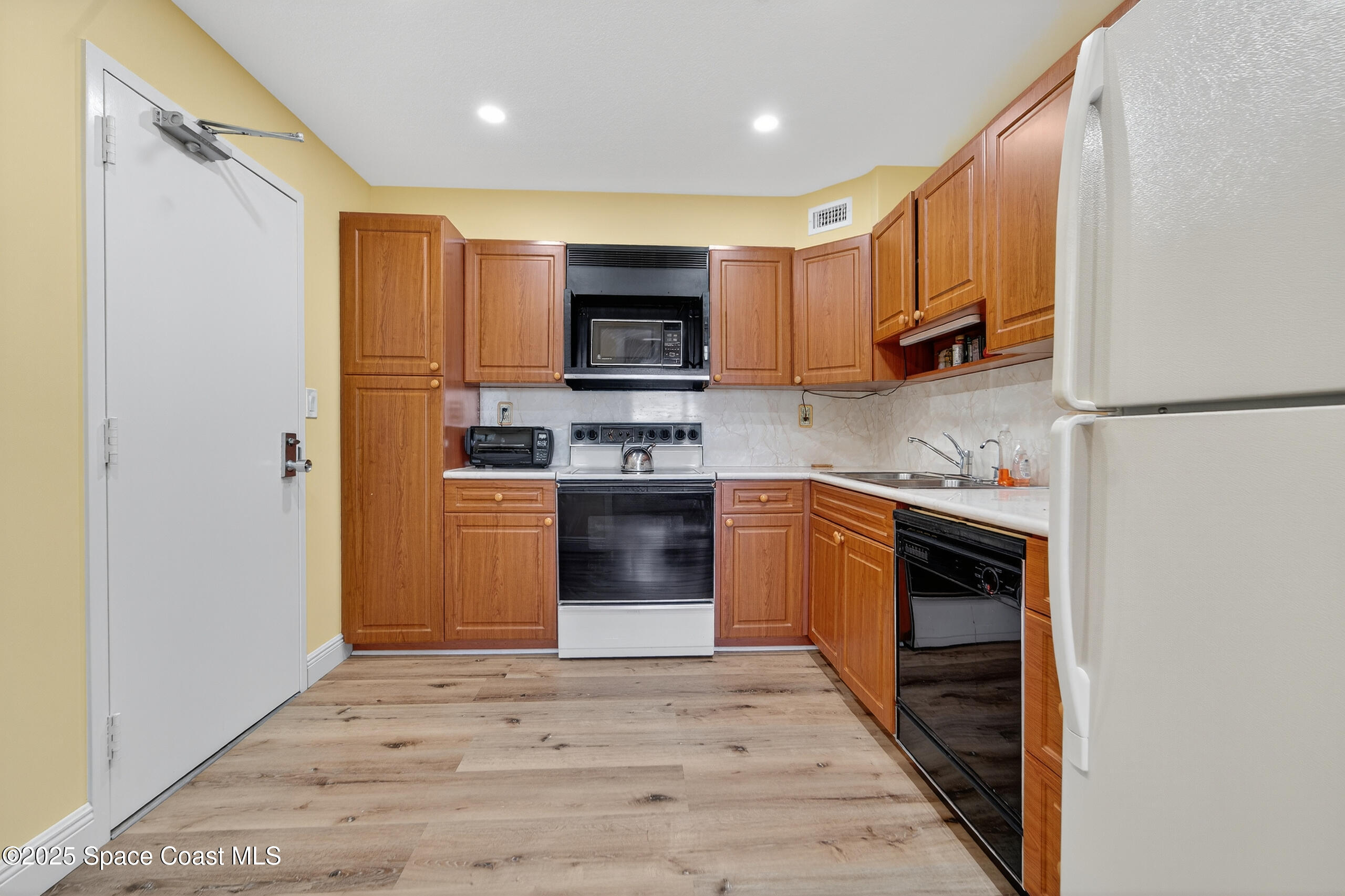 10777 West Sample Road, Unit 1212 Coral Springs, FL 33065 - Photo 14 of 41 a kitchen with stainless steel appliances granite countertop a refrigerator a stove top oven a sink and dishwasher