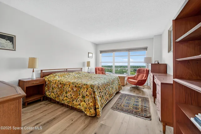 a bedroom with furniture and a large window