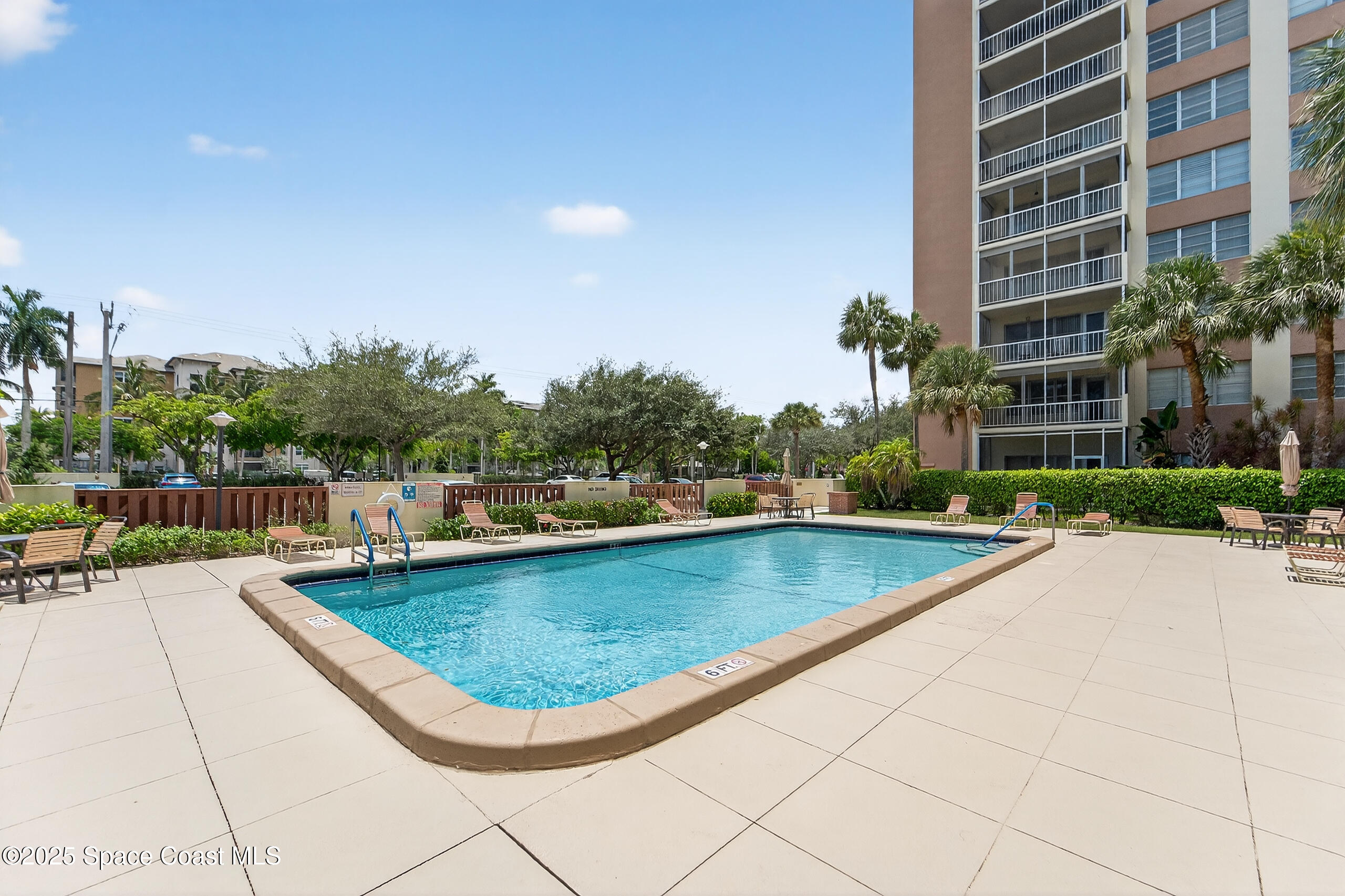 10777 West Sample Road, Unit 1212 Coral Springs, FL 33065 - Photo 31 of 41 a view of a swimming pool with a lounge chair