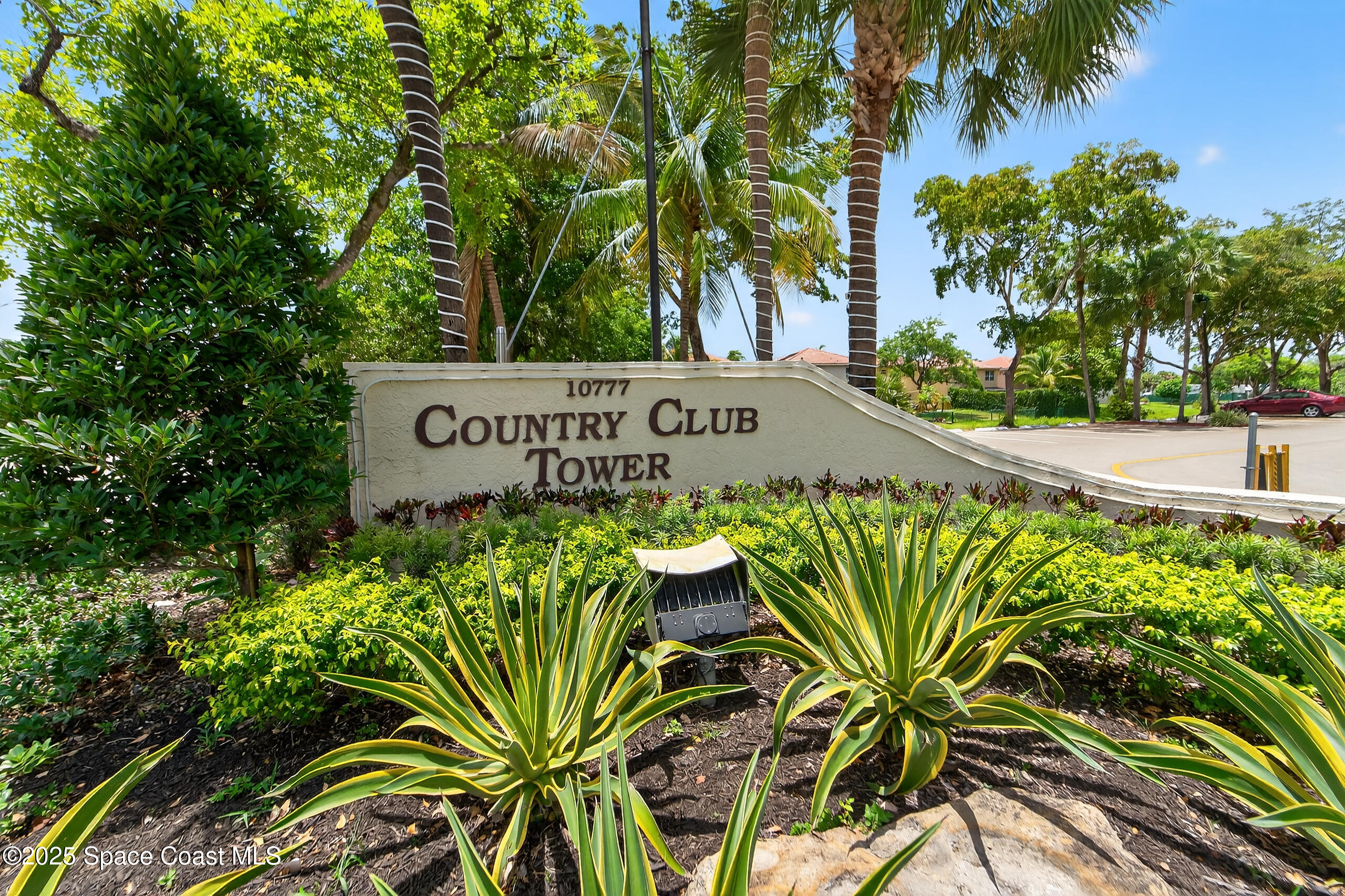 10777 West Sample Road, Unit 1212 Coral Springs, FL 33065 - Photo 34 of 41 a view of sign board with potted plants and palm trees