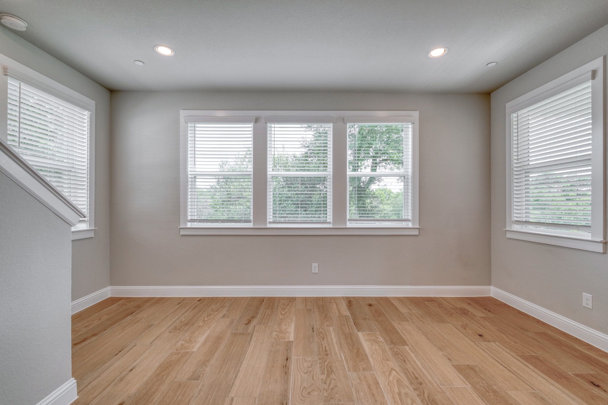 2605 Sam Bass Road, Unit 44 Round Rock, TX 78681 - Photo 14 of 26 Well-lit living area features multiple windows and gleaming hardwood flooring.
