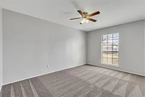 an empty room with windows and ceiling fan