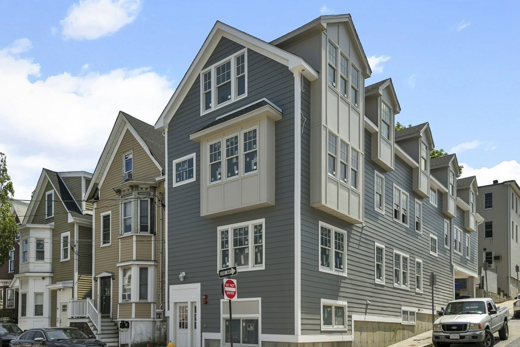 137 Falcon Street, Unit 4 Boston, MA 02128 - Photo 20 of 22 a front view of a residential apartment building with a yard