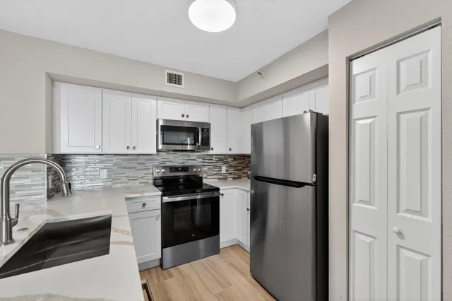 a kitchen with a refrigerator a stove top oven and a counter space