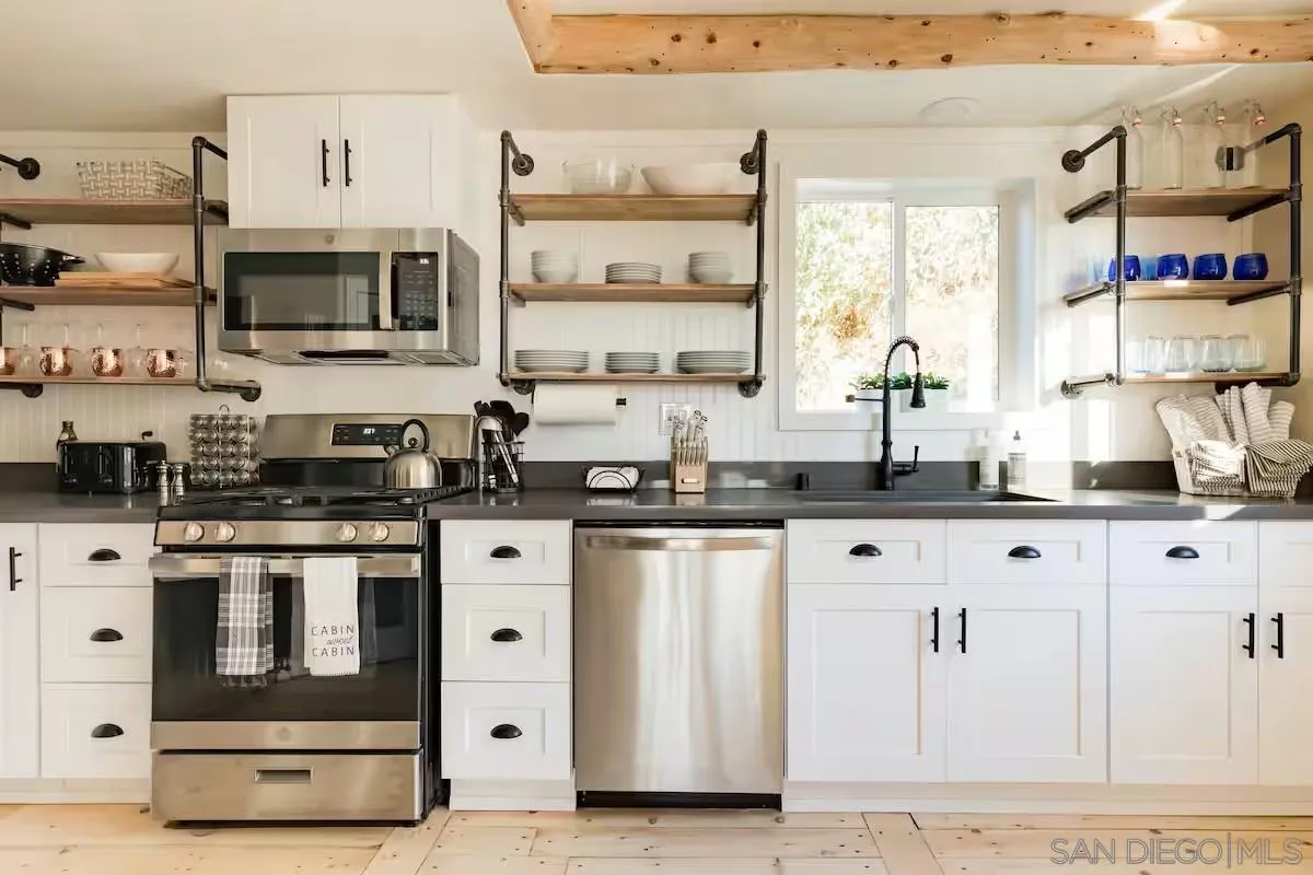 15914 Sequan Truck Trail Alpine, CA 91901 - Photo 8 of 69 a kitchen with stainless steel appliances a stove and white cabinets