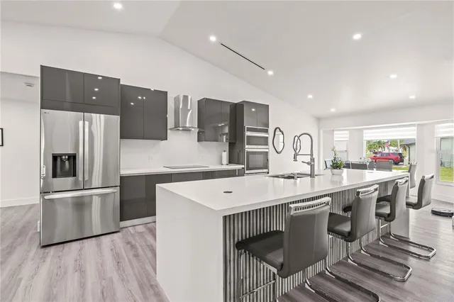 a kitchen with a sink a refrigerator and a stove top oven