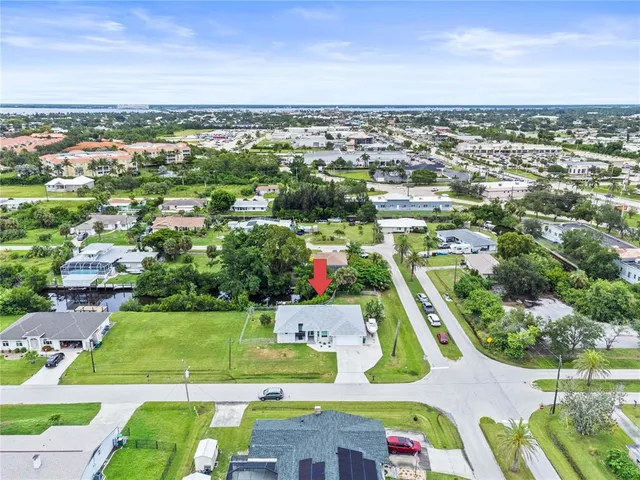 an aerial view of residential houses with outdoor space and trees
