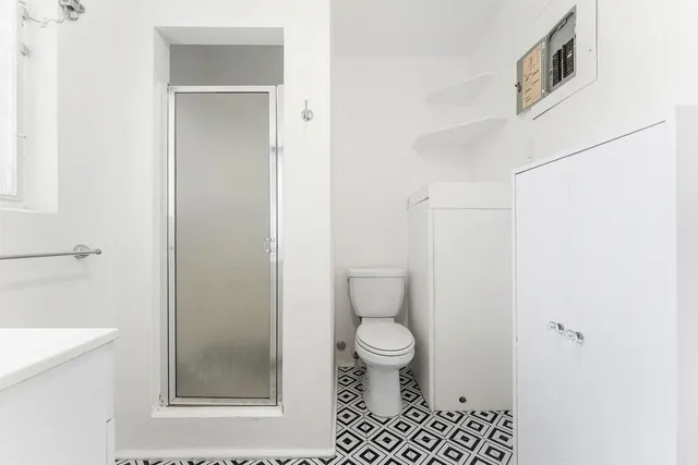 a bathroom with a toilet and a shower