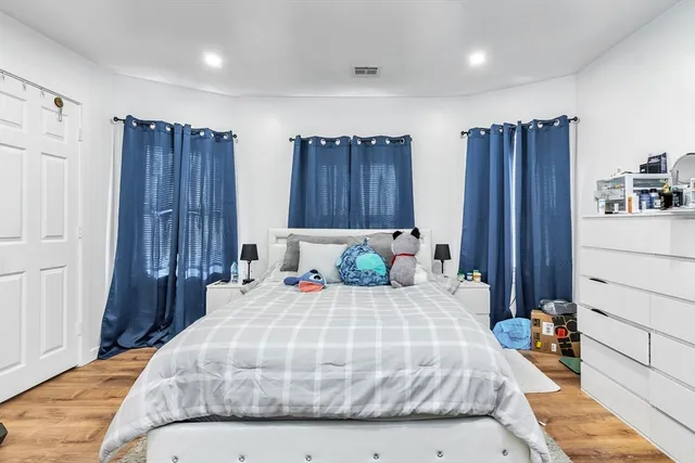 a bedroom with a bed and wooden floor