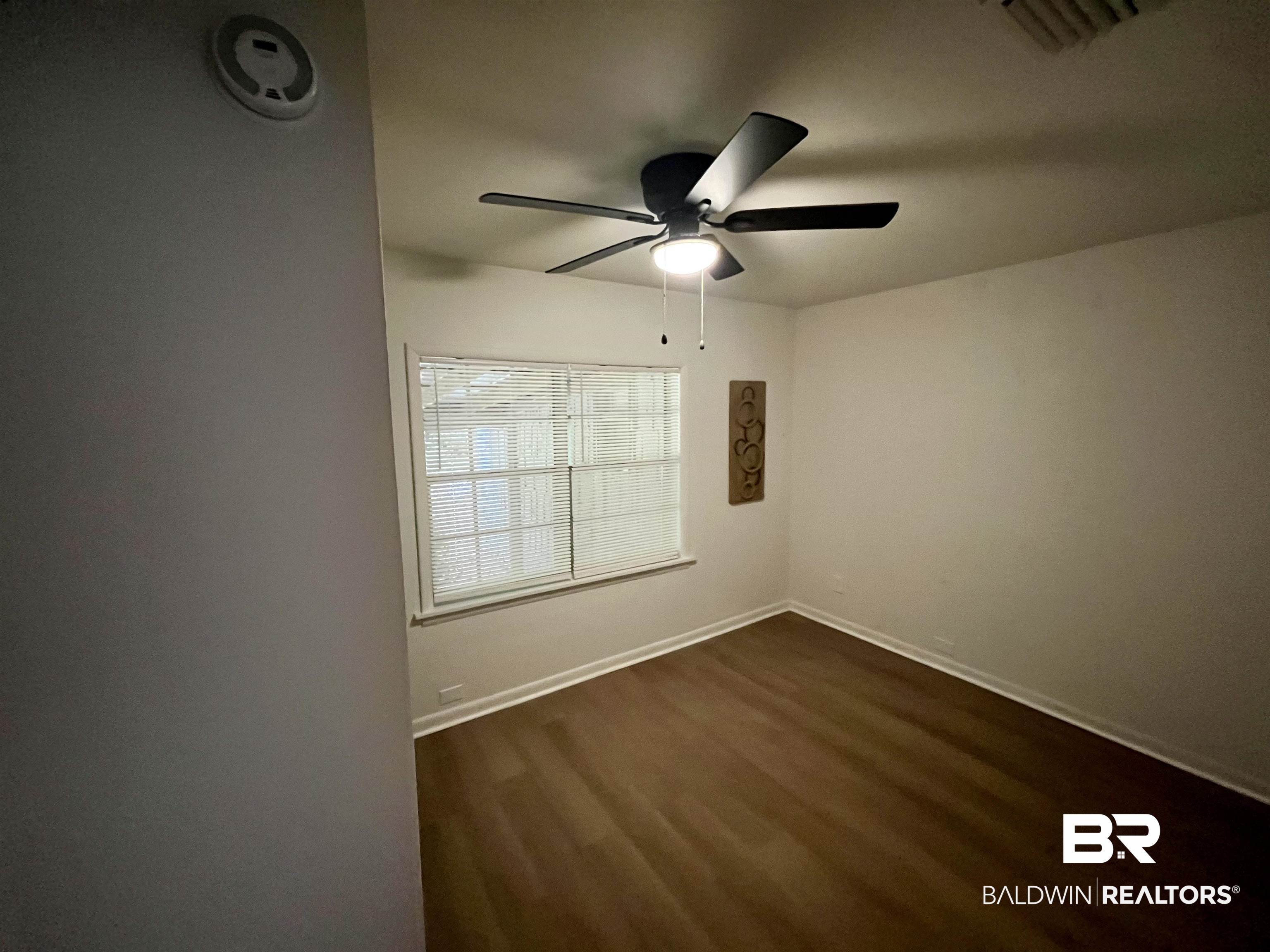 3105 Bryant Road Mobile, AL 36605 - Photo 34 of 39 Room featuring wood-finish flooring, a ceiling fan with integrated lighting, and a window with horizontal blinds