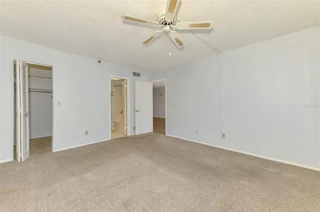 an empty room with chandelier fan