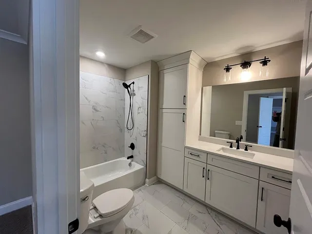 a bathroom with a double vanity sink toilet mirror and bathtub