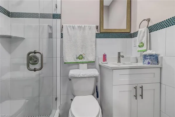 a bathroom with a toilet sink vanity and shower