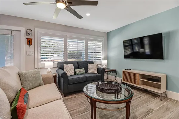a living room with furniture a flat screen tv and a window