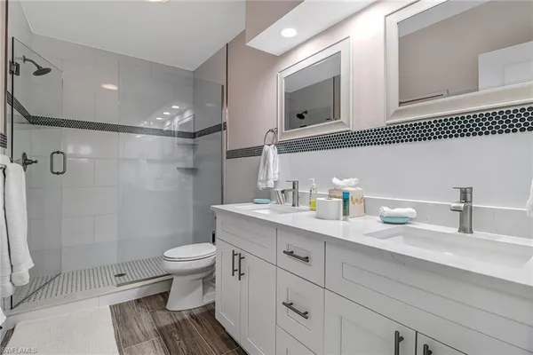 a bathroom with a granite countertop sink a toilet and a mirror