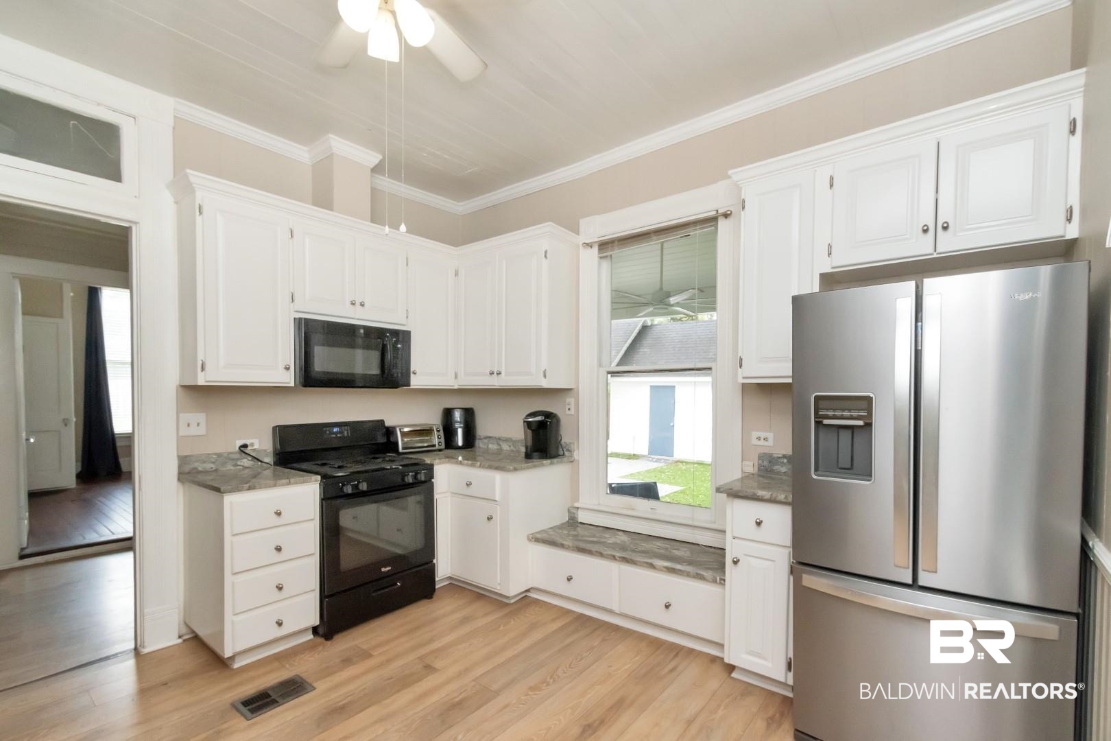 1305 Brown Street Mobile, AL 36604 - Photo 5 of 37 Kitchen featuring black appliances, white cabinets, crown molding, and light wood-type flooring