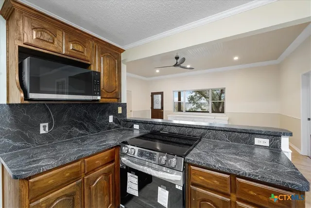 a kitchen with stainless steel appliances granite countertop a sink a stove microwave and cabinets