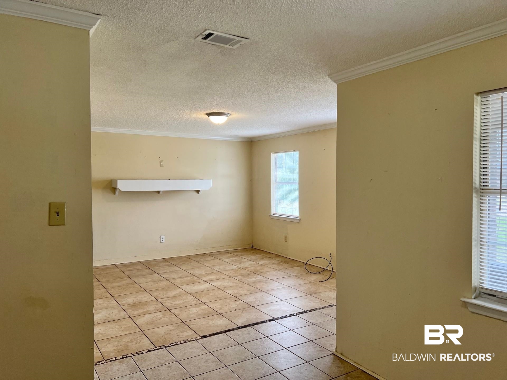 72 Grimes Lane Loxley, AL 36551 - Photo 8 of 12 Spare room with ornamental molding, light tile patterned floors, and a textured ceiling