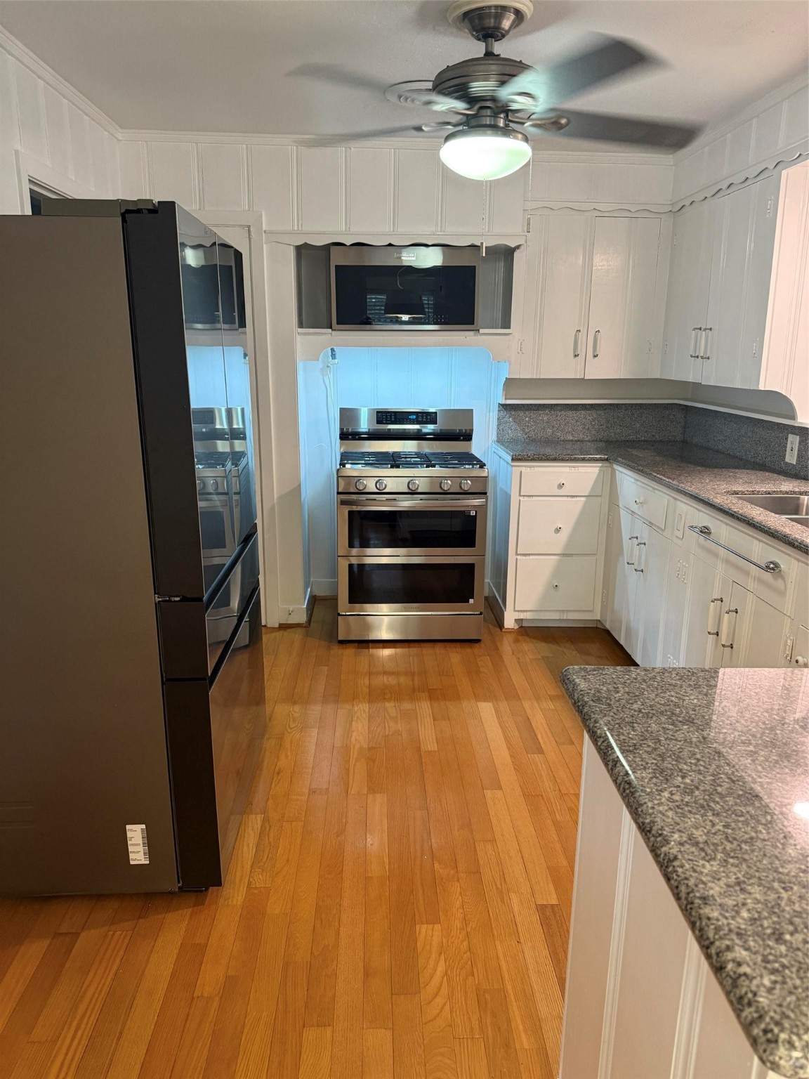 4114 Norfolk Street Houston, TX 77027 - Photo 3 of 7 a kitchen with granite countertop a refrigerator and a stove top oven