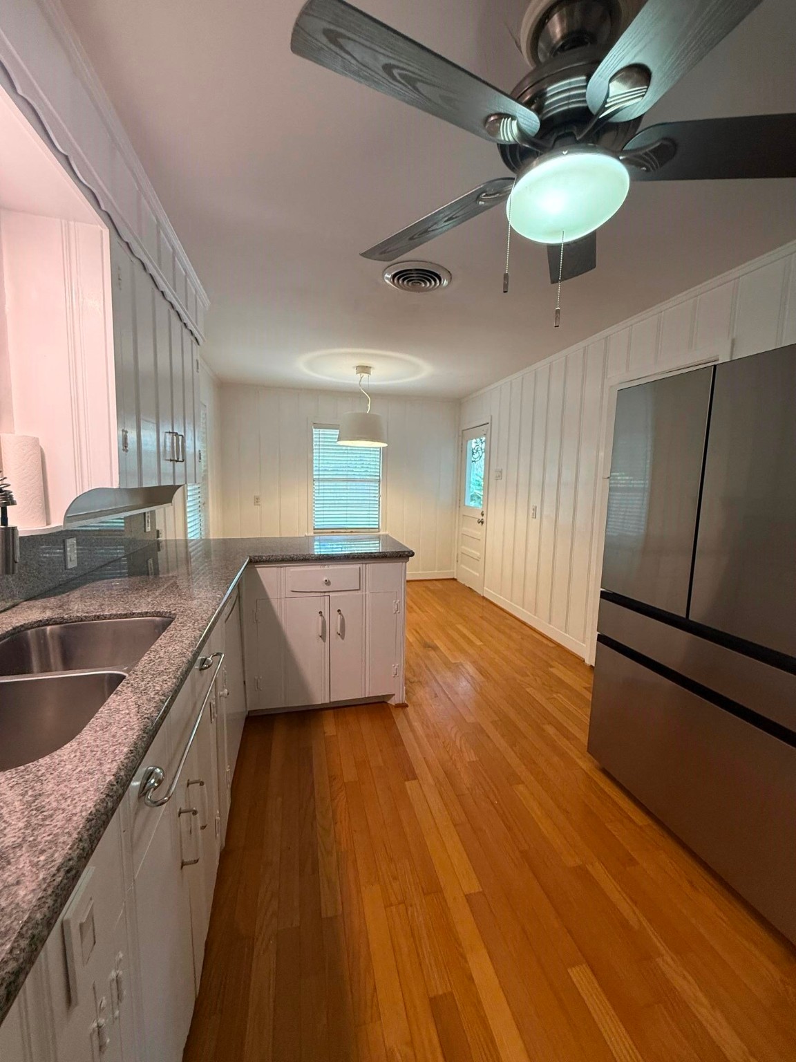 4114 Norfolk Street Houston, TX 77027 - Photo 4 of 7 a kitchen with stainless steel appliances granite countertop a sink cabinets and wooden floor