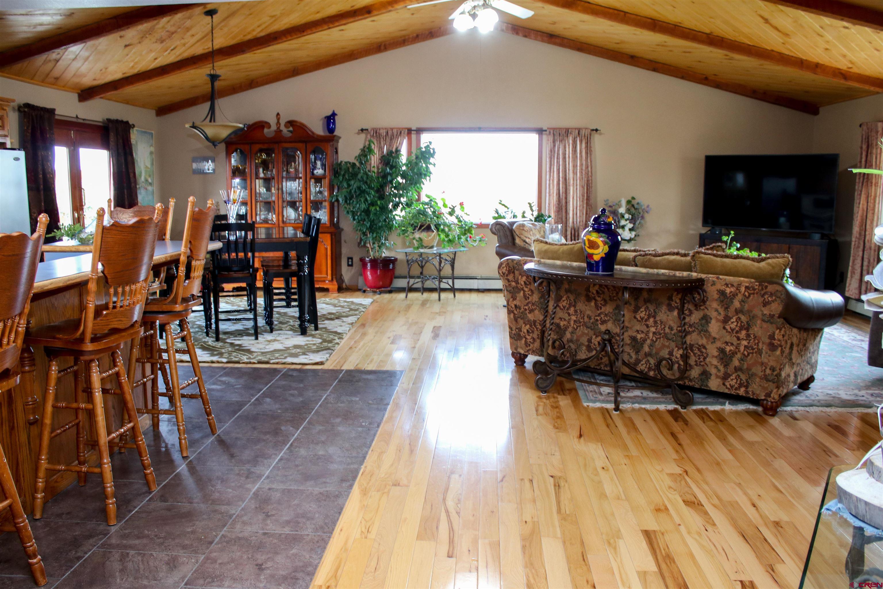 58811 Banner Road Olathe, CO 81425 - Photo 6 of 35 a living room with furniture a flat screen tv and a floor to ceiling window