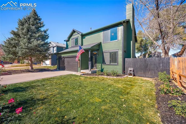 a view of a house with backyard and a tree