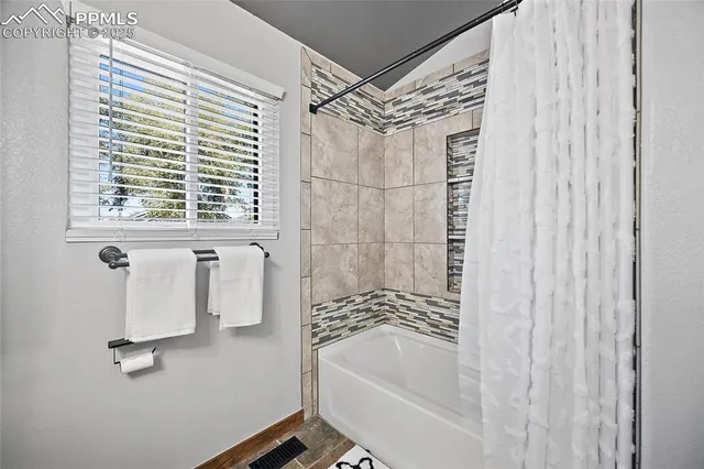 a bathroom with a shower curtain and a bathtub