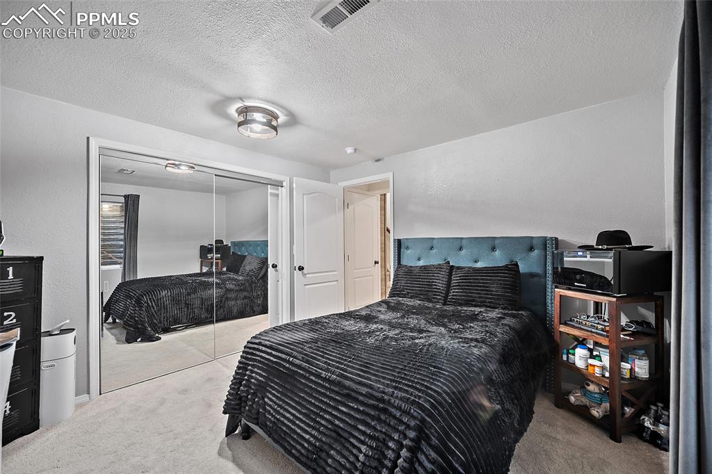 7015 Reunion Circle Fountain, CO 80817 - Photo 25 of 41 a bedroom with a bed and a mirror