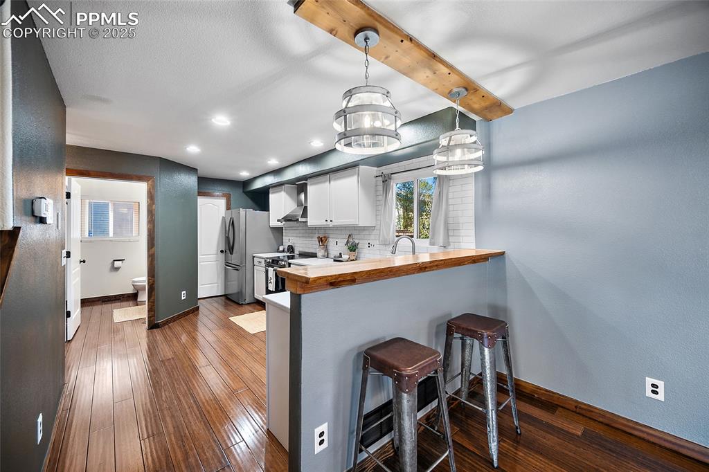7015 Reunion Circle Fountain, CO 80817 - Photo 10 of 41 a kitchen with stainless steel appliances a table chairs in it and wooden floors