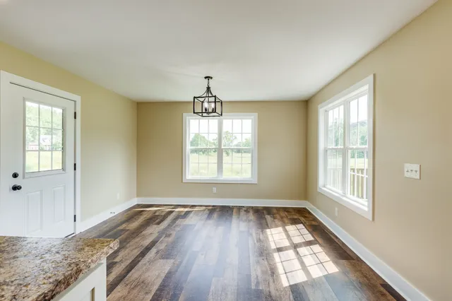 a view of a livingroom with wooden floor and a window