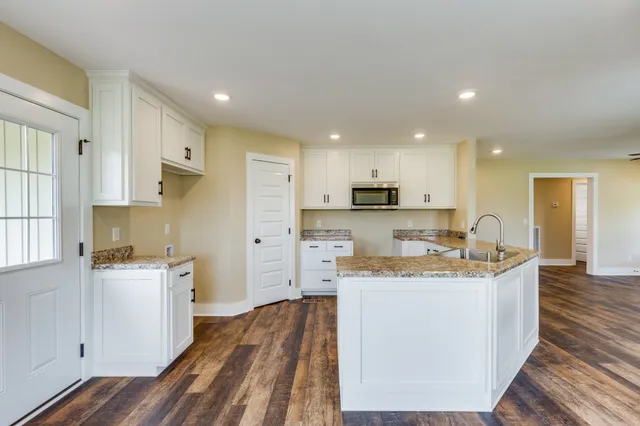 a kitchen with granite countertop a sink stove and cabinets