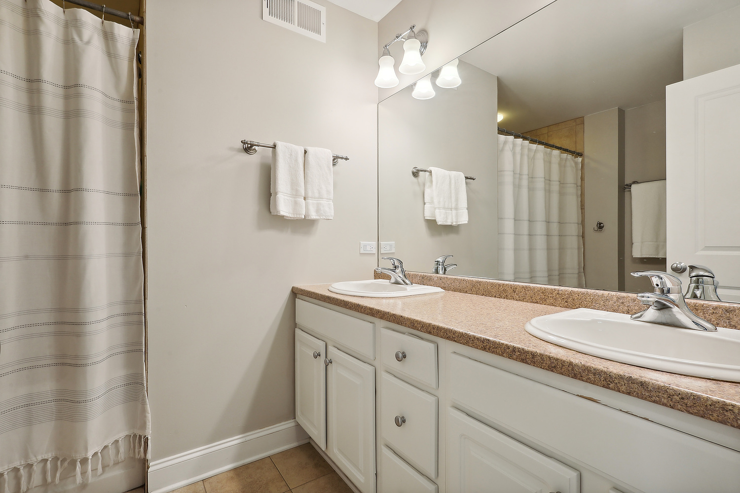 2432 Illinois Road Northbrook, IL 60062 - Photo 13 of 22 a bathroom with a granite countertop sink a mirror and a shower