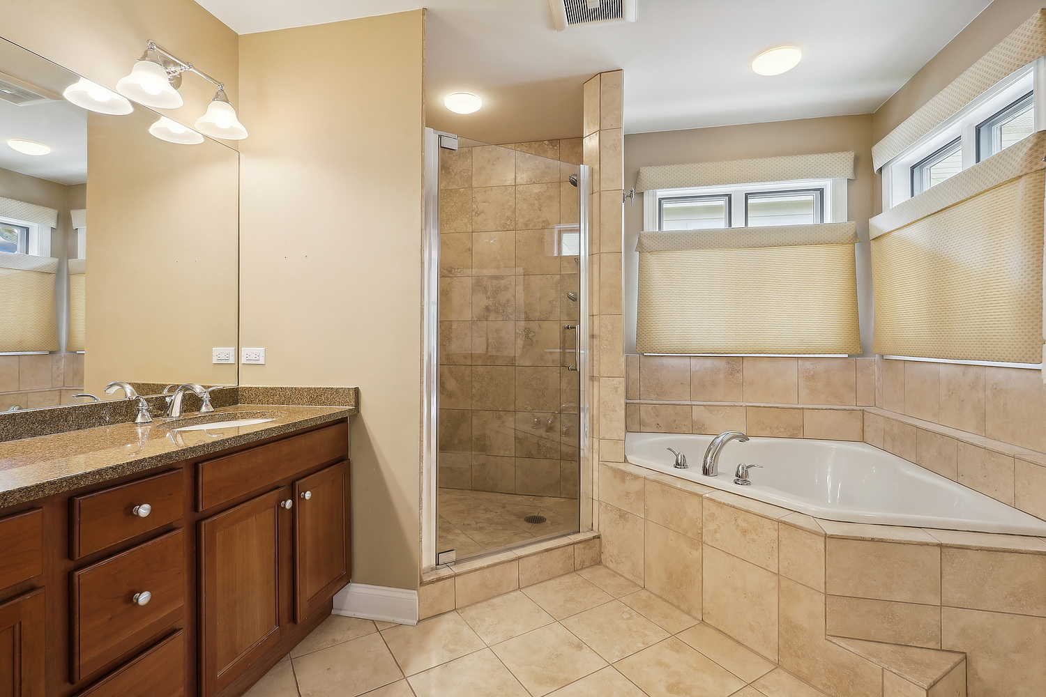2432 Illinois Road Northbrook, IL 60062 - Photo 10 of 22 a bathroom with a granite countertop sink a mirror and a bathtub
