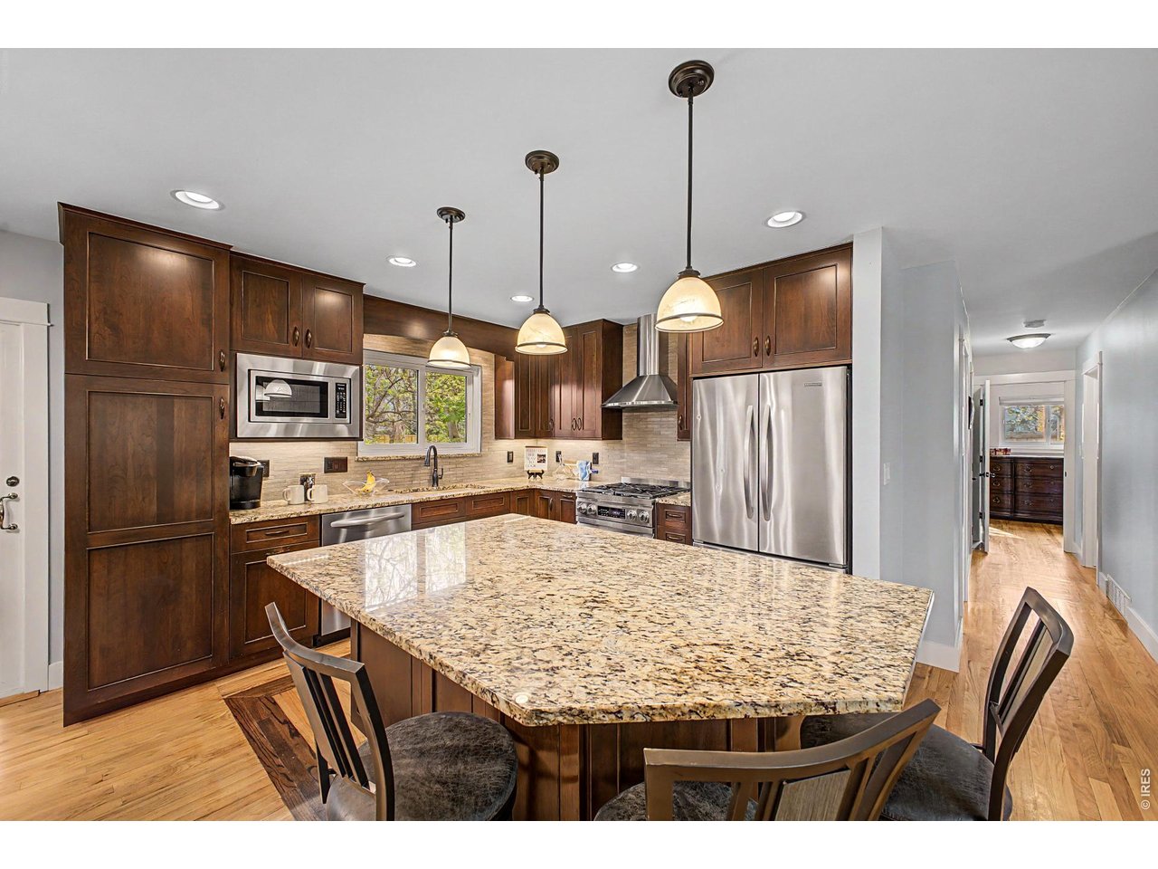 1453 Chestnut Place Boulder, CO 80304 - Photo 13 of 32 a kitchen with stainless steel appliances kitchen island granite countertop a table chairs and refrigerator
