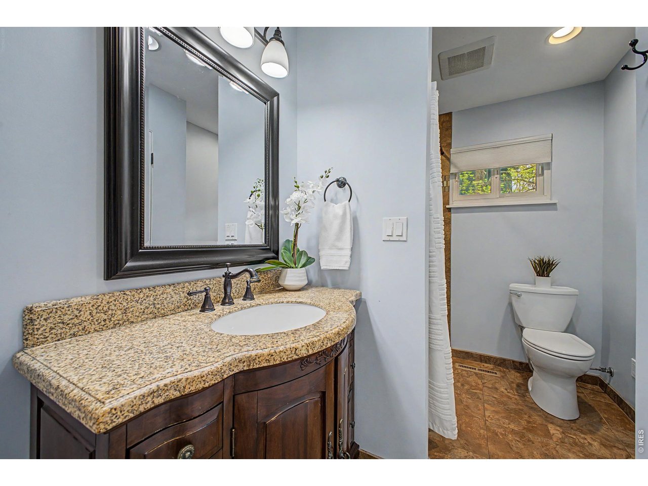 1453 Chestnut Place Boulder, CO 80304 - Photo 20 of 32 a bathroom with a granite countertop sink a toilet and a mirror