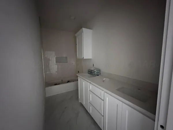 a bathroom with a granite countertop sink a toilet and bathtub
