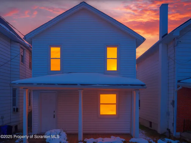 a view of a brick house with a small yard