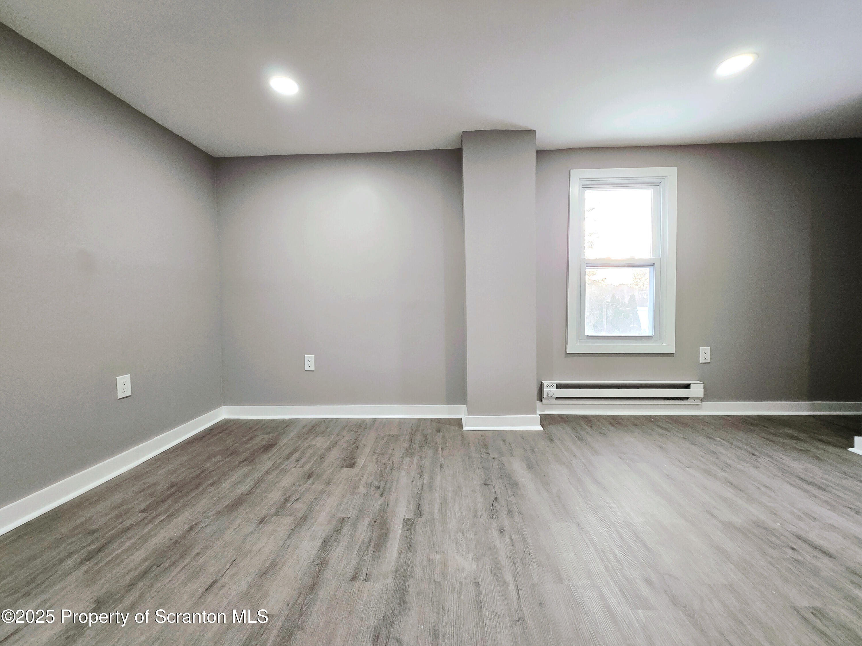 1215 Eynon Street Scranton, PA 18504 - Photo 17 of 32 an empty room with wooden floor and windows