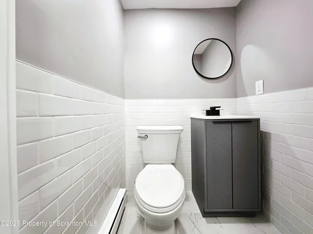 a bathroom with a toilet a sink and a mirror