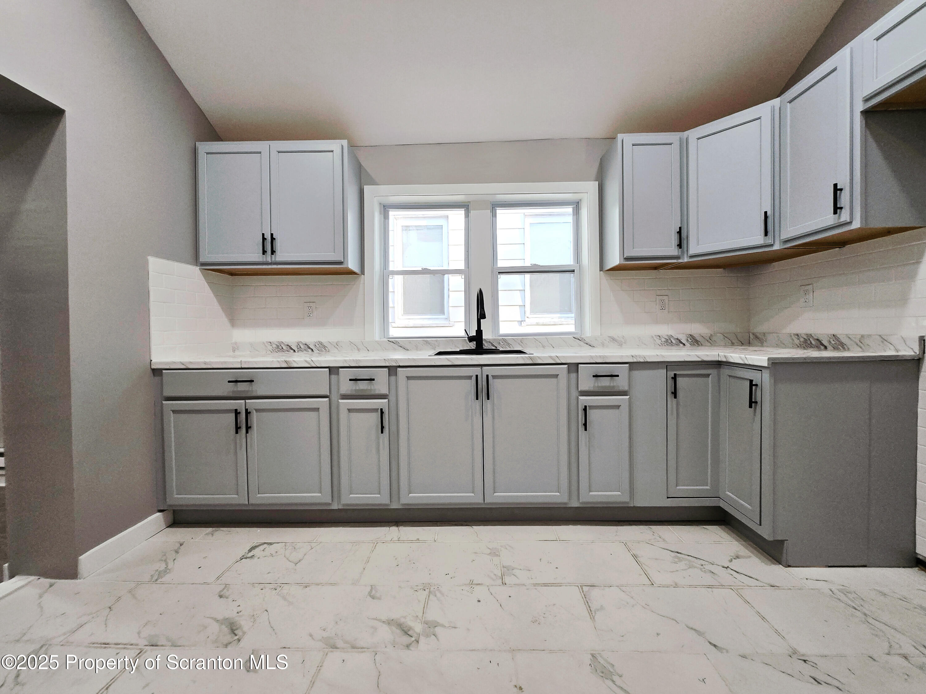 1215 Eynon Street Scranton, PA 18504 - Photo 4 of 32 a kitchen with granite countertop a sink stove and cabinets