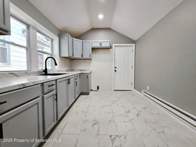 a kitchen with granite countertop a sink stainless steel appliances and cabinets