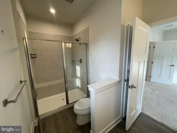a bathroom with a granite countertop toilet and a shower