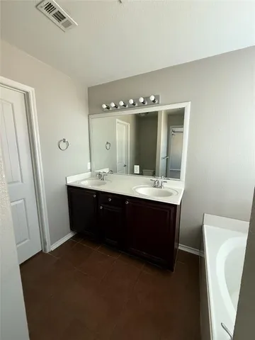 a spacious bathroom with a double vanity sink and a mirror