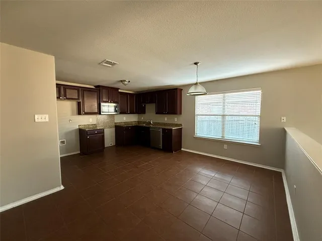 a large kitchen with a stove a refrigerator and a stove top oven