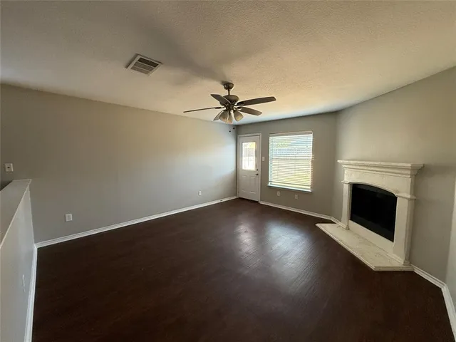 an empty room with windows and fireplace