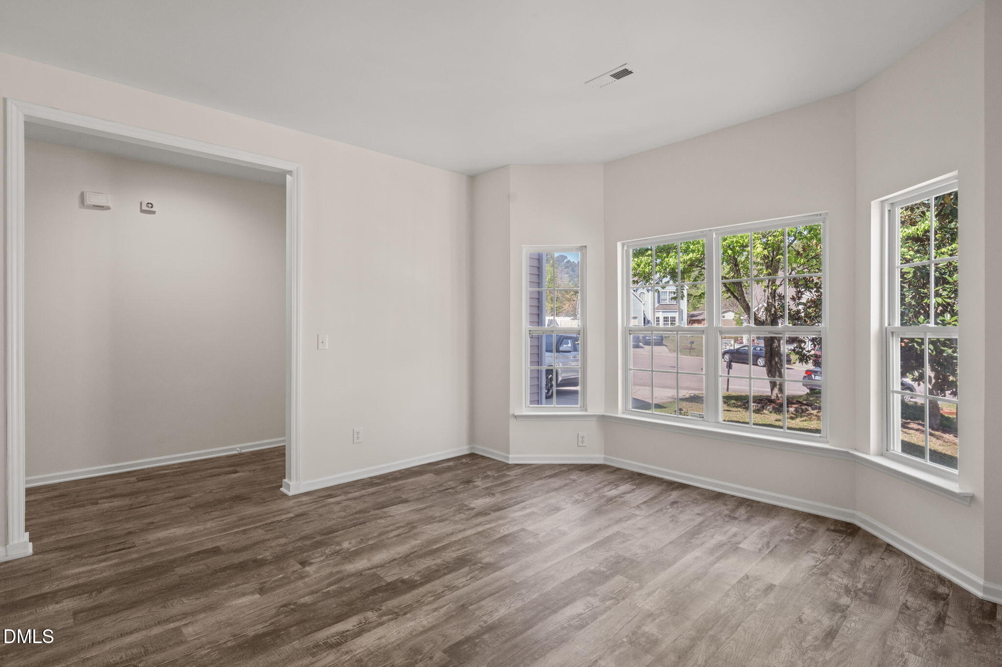 3207 Geary Trail Raleigh, NC 27610 - Photo 5 of 55 a view of an empty room with wooden floor and a window