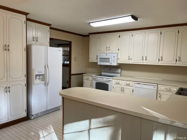 a kitchen with cabinets and a refrigerator