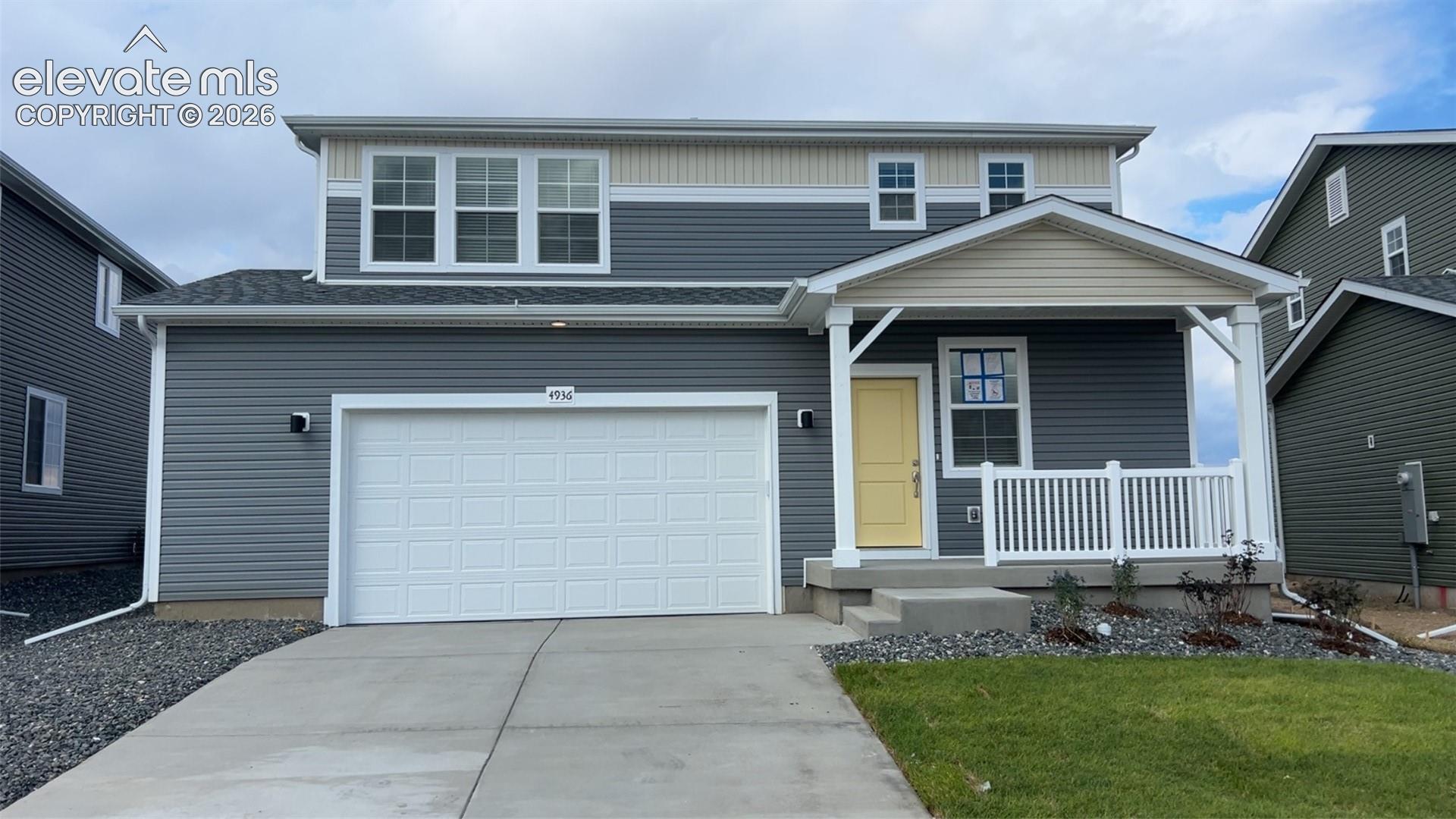 4936 Truscott Road Colorado Springs, CO 80925 - Photo 1 of 41 Modern exterior featuring gray siding, white trim, and a prominent white garage door