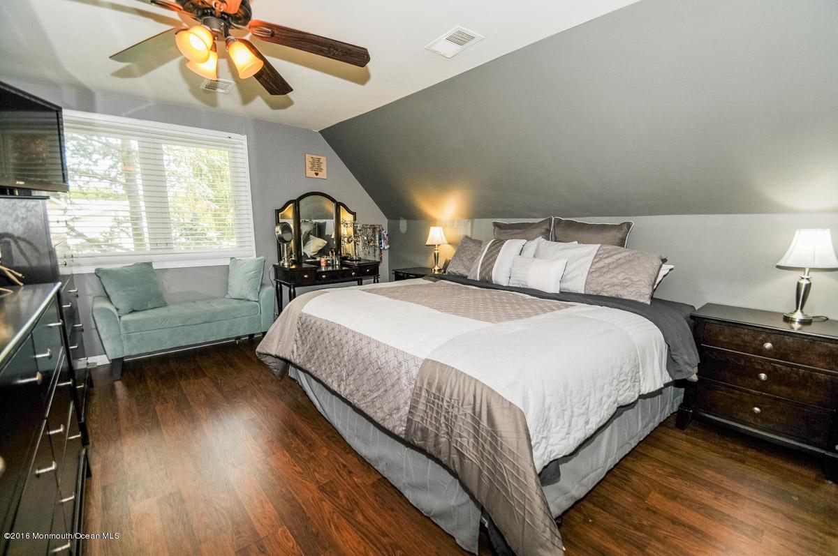 13 Valley Road Manalapan, NJ 07726 - Photo 19 of 26 a spacious bedroom with a bed a chandelier and a window