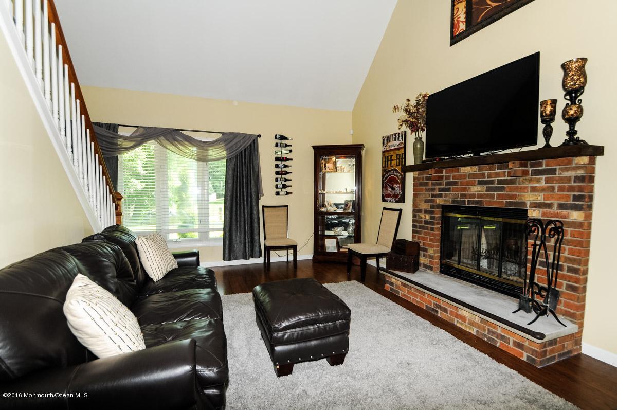 13 Valley Road Manalapan, NJ 07726 - Photo 6 of 26 a living room with furniture flat screen tv and a fireplace